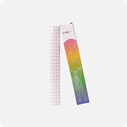 Roll of grid paper next to a colorful packaging box on a white background
