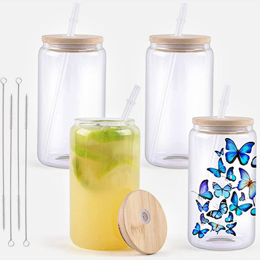 Set of glass jars with wooden lids and straws, one containing a green drink with a slice of lime.